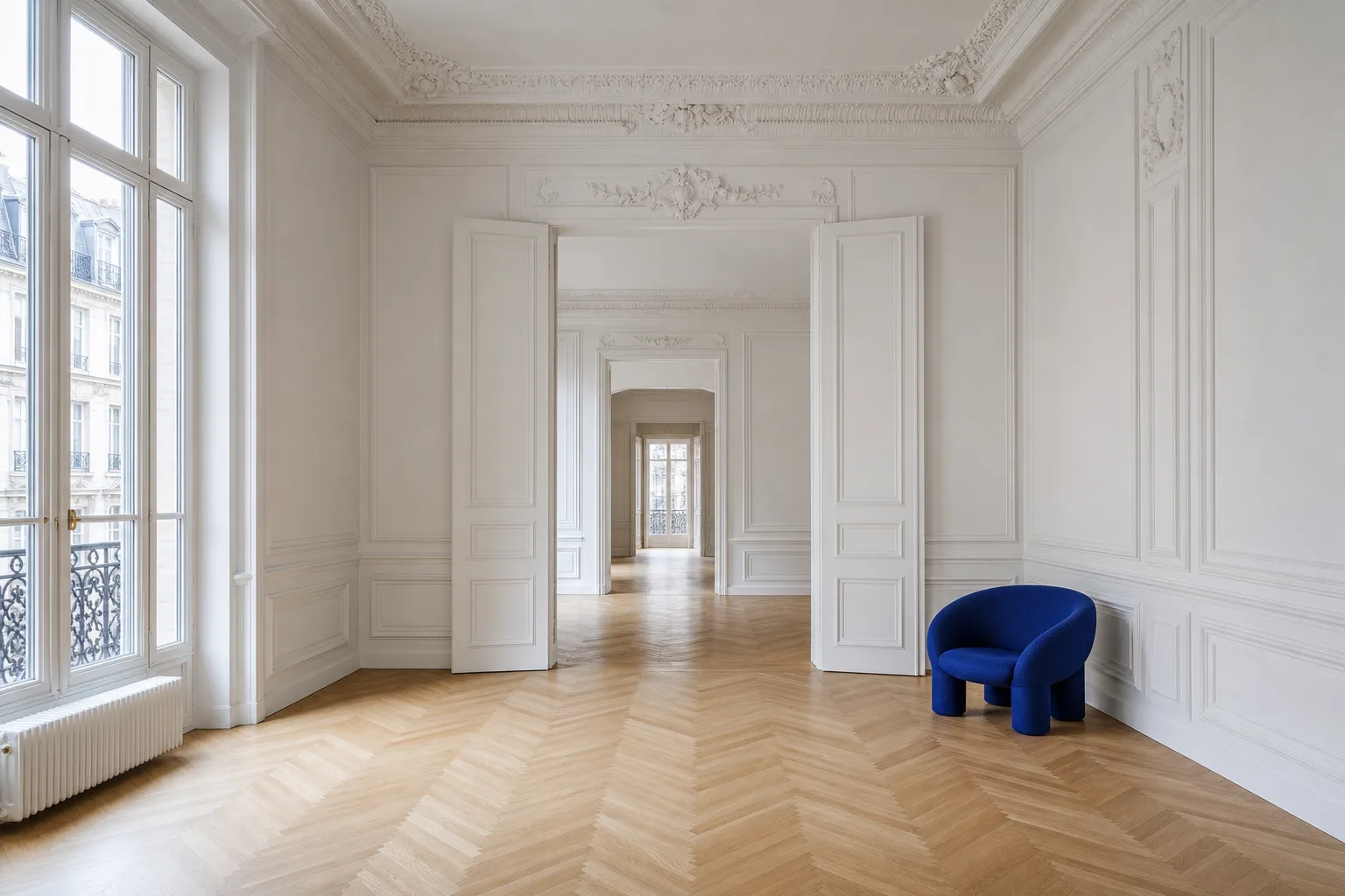 Appartement lumineux à vendre : grande verrière, parquet en chevrons, une chaise bleu cobalt