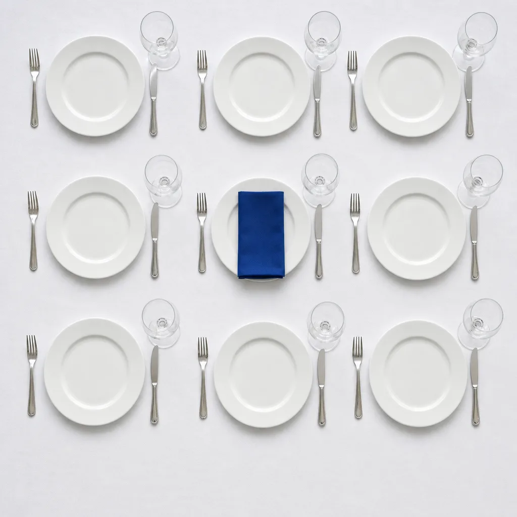 Table de banquet dressée au cordeau, une serviette en lin bleu cobalt